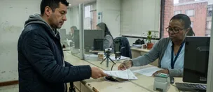 Usuario entrega documentos en una ventanilla de atención para un trámite de licencia
